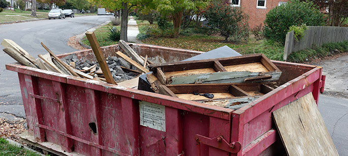 dumpster in road full of demo debris