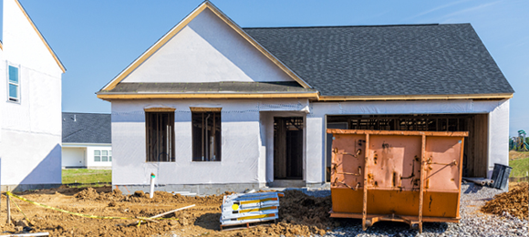 Roll-off dumpster on new home construction worksite 