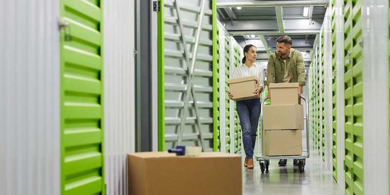 couple moving items out of indoor storage unit