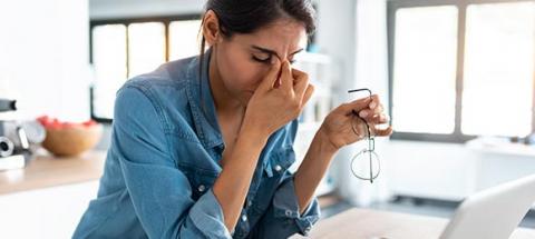 woman rubbing temple in distress