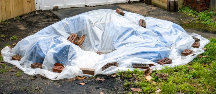 Waste and debris tarped to prevent getting wet
