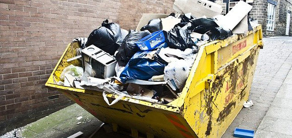 roll-off dumpster full of garbage and household junk