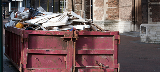 construction dumpster full of debris on a worksite
