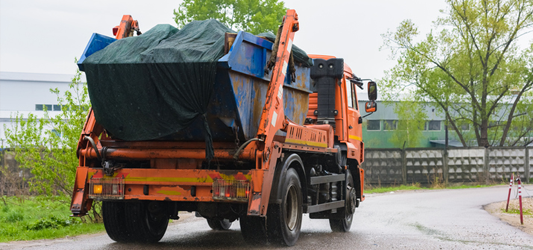 Full roll-off container loaded on a dumpster hauling truck