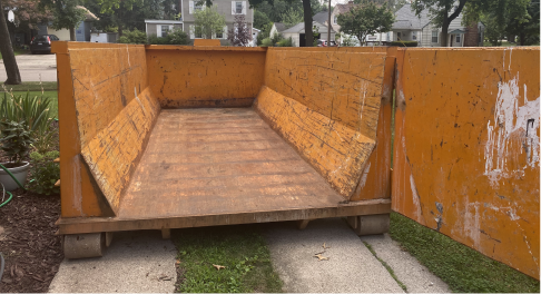 open dumpster fitting perfectly in driveway