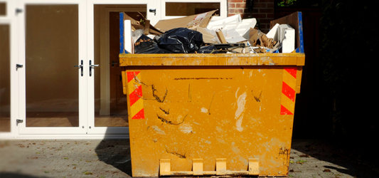 Dumpster in residential driveway full of household items